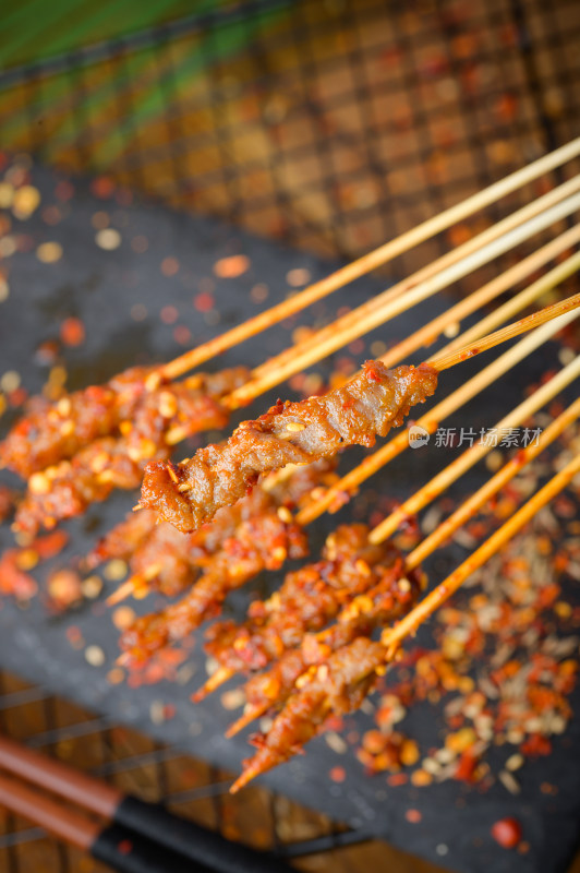 手持撒料的烤肉串特写