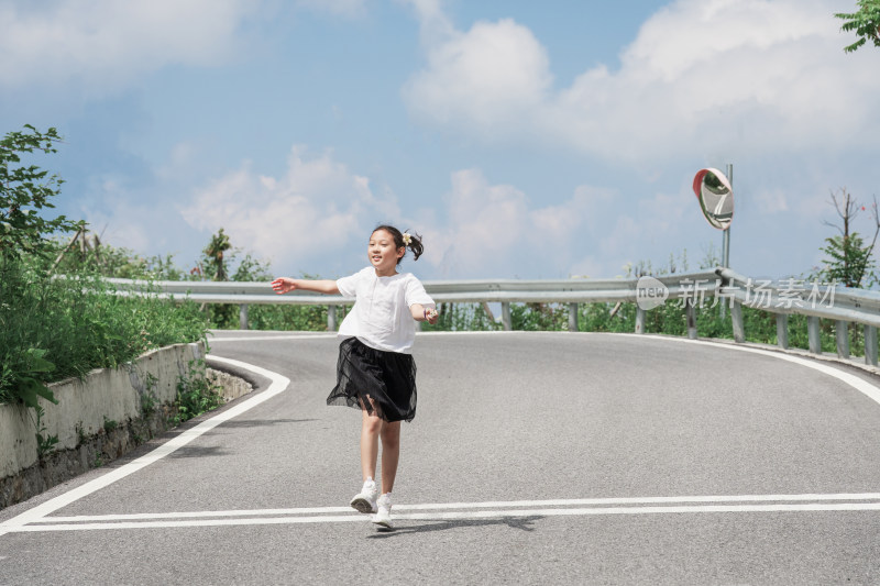 晴朗的夏天午后走在盘山公路上的东方女孩