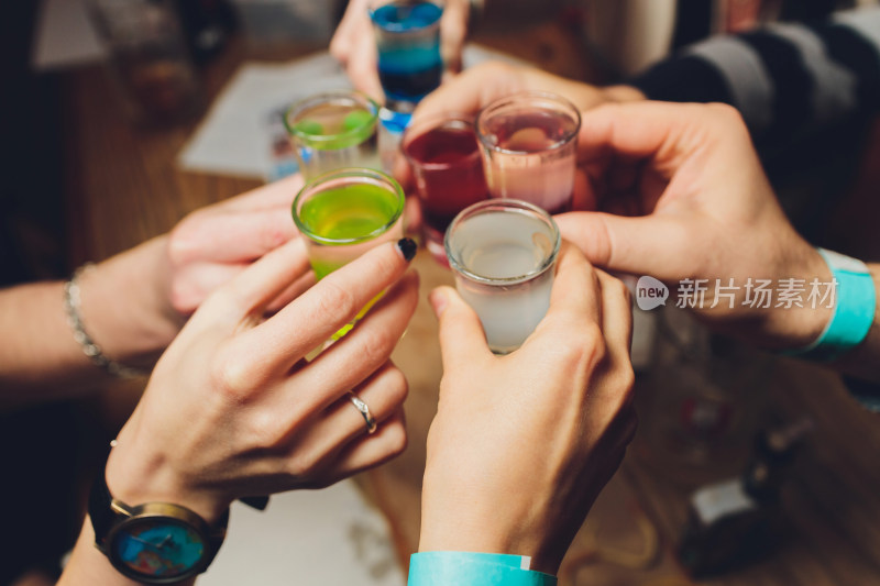 多人举杯共饮彩色饮品