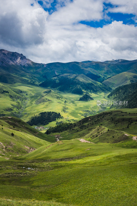 蓝天白云下广袤草原与连绵山峦自然风景