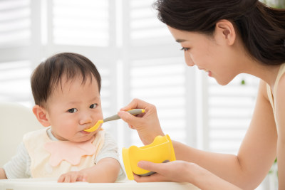 年轻妈妈喂宝宝吃饭