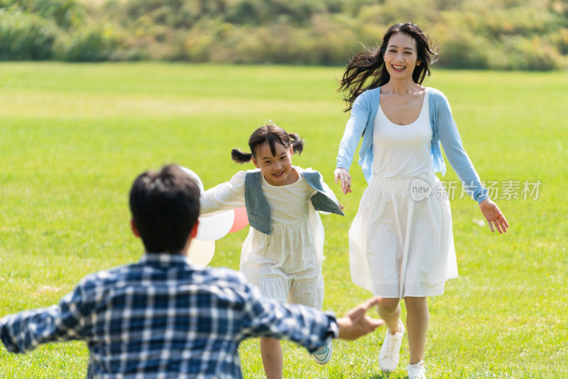 妈妈和女儿开心地跑向爸爸的怀抱