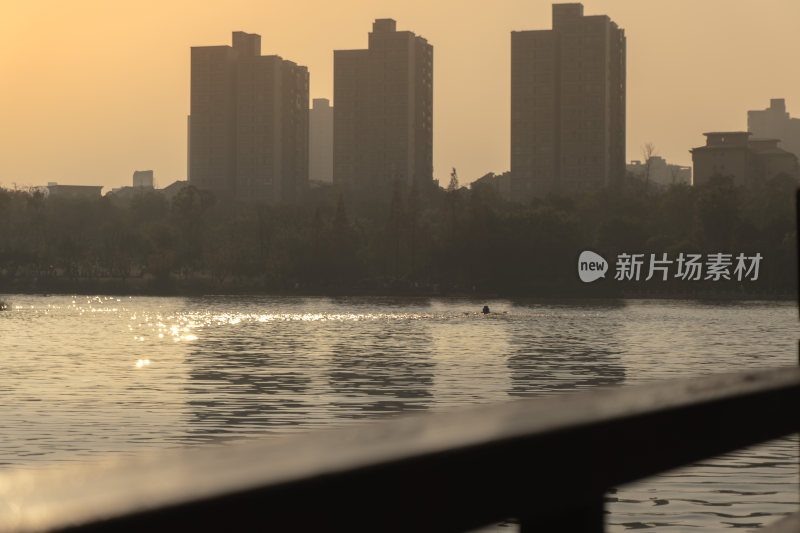 夕阳下湖边的城市高楼景观