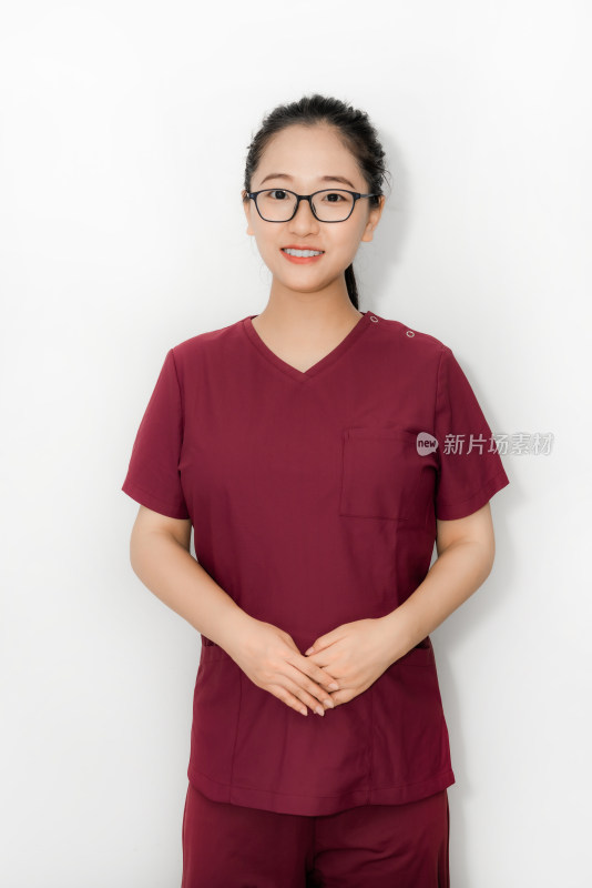 白色背景前穿着手术服的中国年轻女性医生