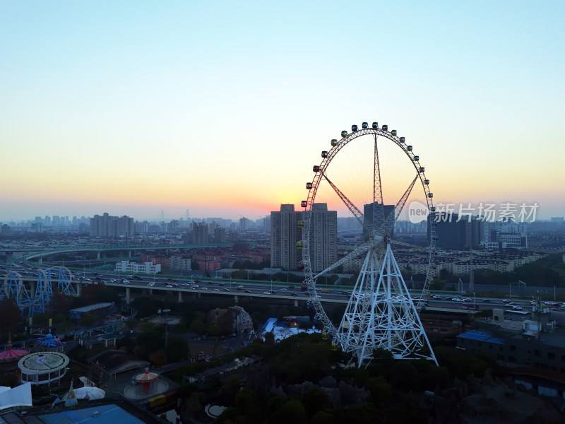 夕阳下城市中的摩天轮全景