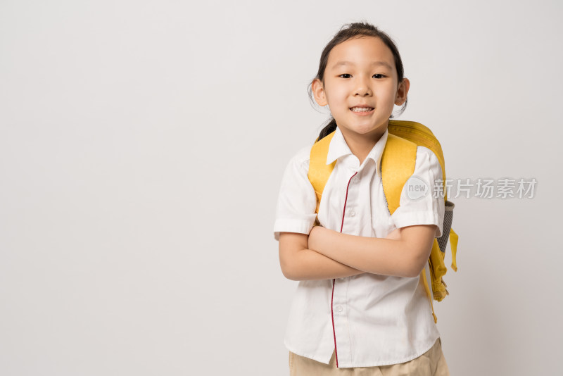 白色背景前背书包穿校服的中国女孩