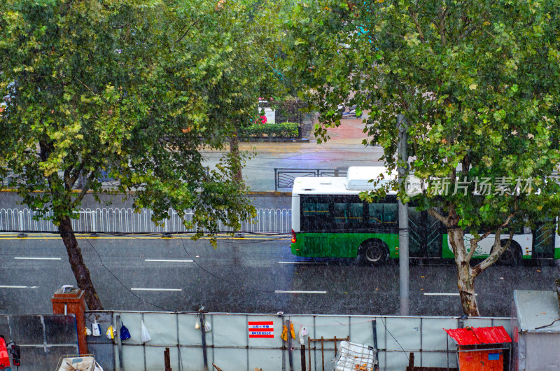 青岛下雨的路上有公交车驶过