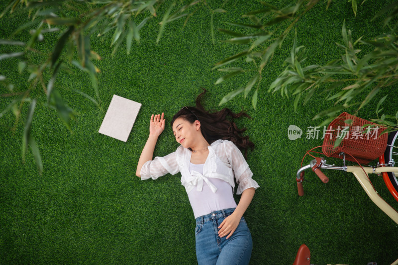 躺在草地上享受大自然的青年女人