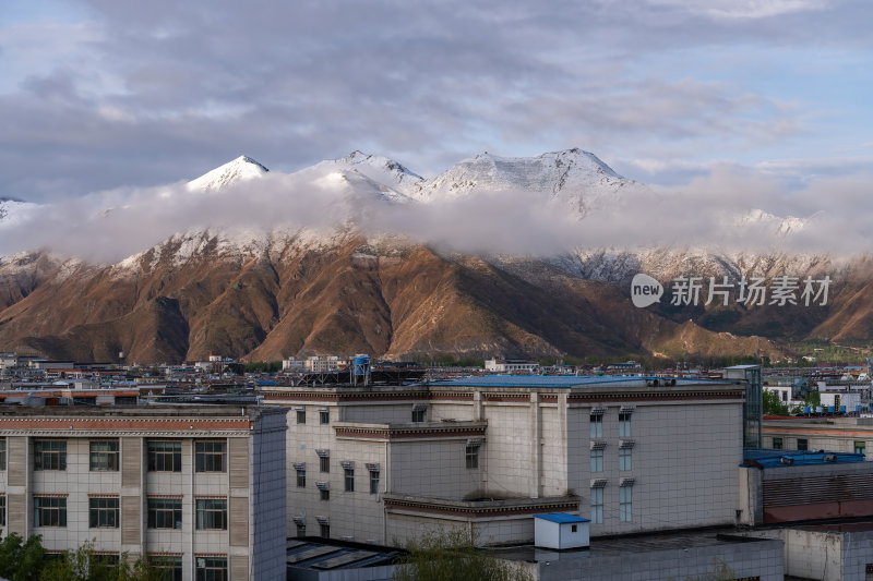 西藏拉萨雪山下的城市建筑高原城市冬日雪景