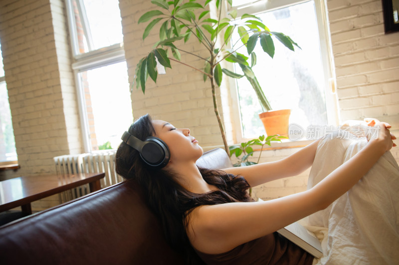 年轻女人在家听音乐看书