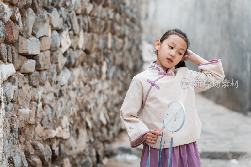 穿中国传统服饰走在古院落街道上的女孩
