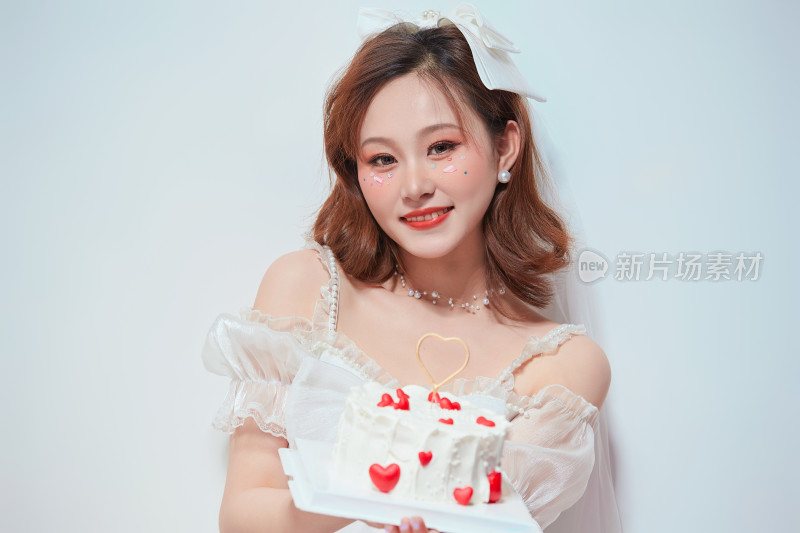 穿着公主裙手捧蛋糕庆祝生日的亚洲女性
