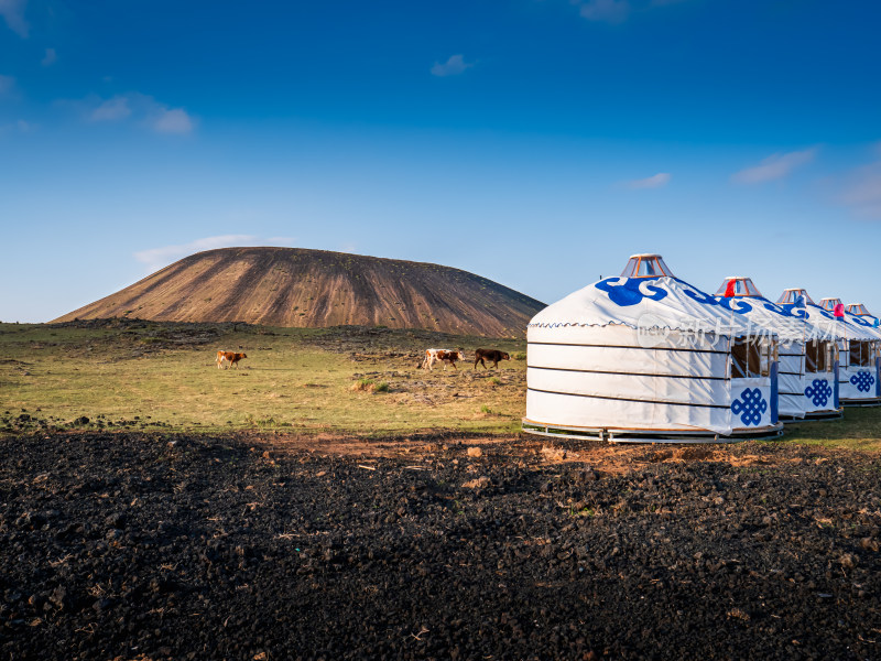 蓝调时刻的蒙古包、牛群与火山