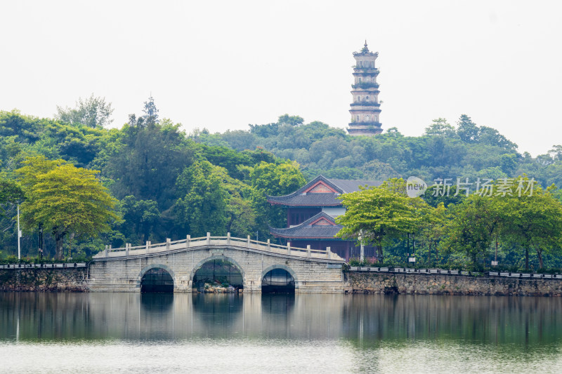 晴朗天空下湖面上的三孔桥和中式古塔建筑