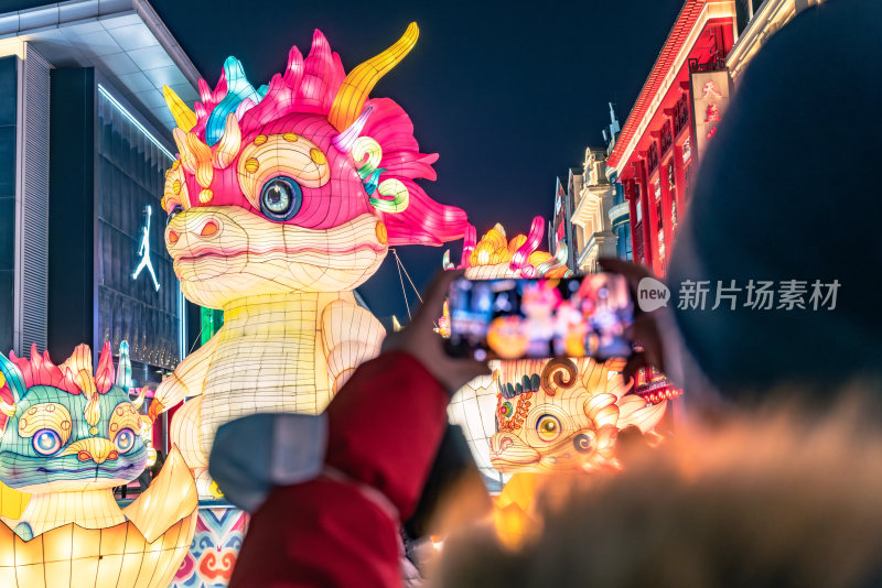 春节期间游客逛街赏花灯用手机拍照留念