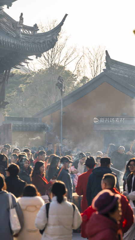 古建筑前众人烧香祈福的热闹景象