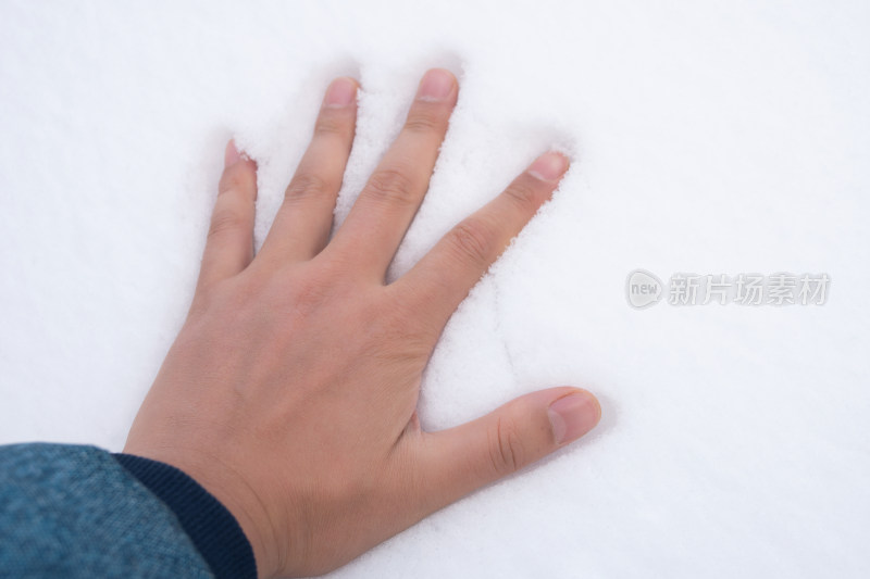 降雪之后一只手摸在雪地上