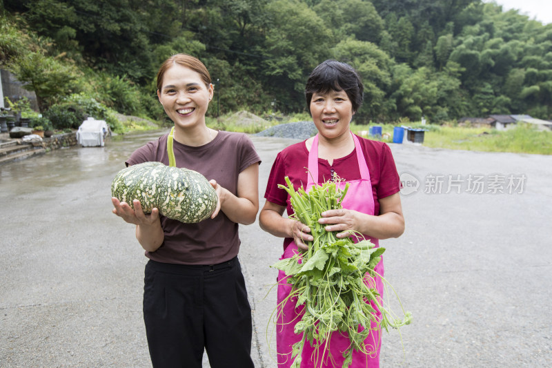 拿着刚采摘的自家种的蔬菜的妇女