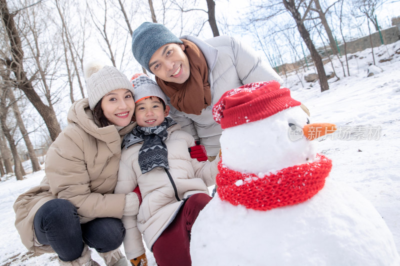 一家三口在雪地里堆雪人