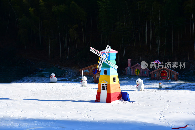 雪地中多彩风车建筑，周边有雪人点缀