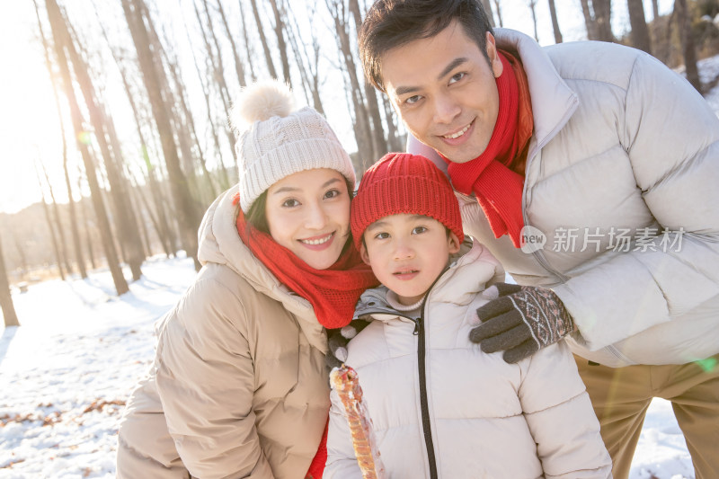 在雪地上玩耍的一家三口