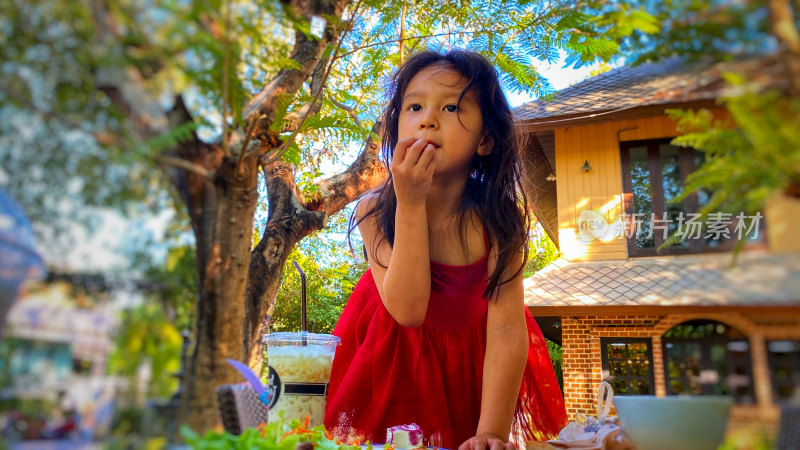 穿红裙小女孩户外用餐场景