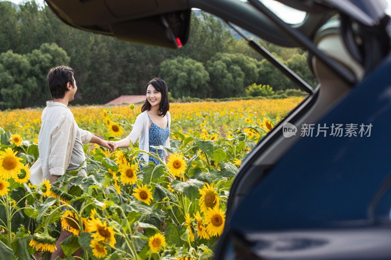 站着花海里的青年夫妇