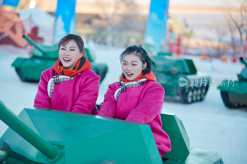 在冰天雪地玩耍雪上娱乐载具车辆的闺蜜少女