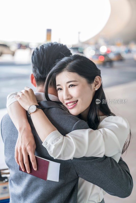 年轻情侣在机场团聚拥抱