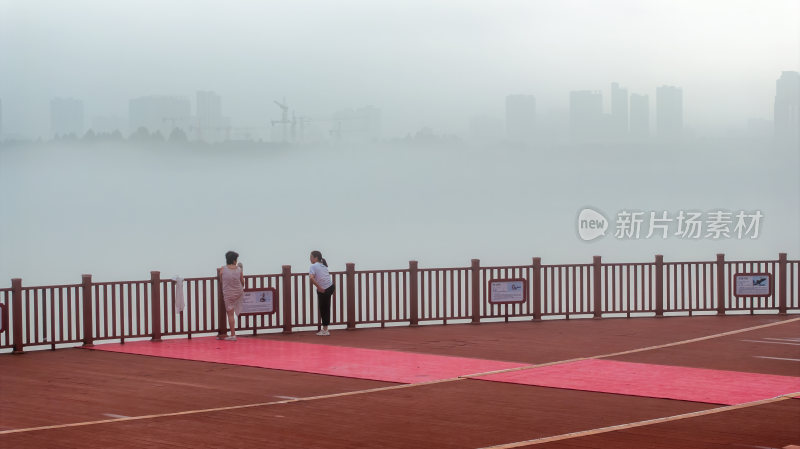 城市清晨雾气中体育运动锻炼身体休闲的市民