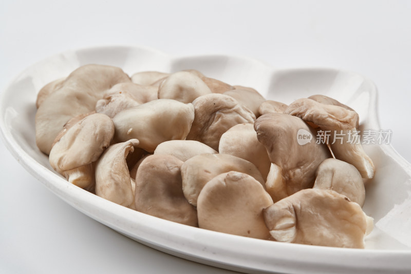 白色瓷盘装的火锅食材山珍蘑