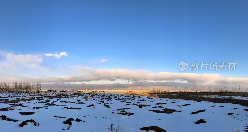 开阔雪地上空的蓝天白云自然景观