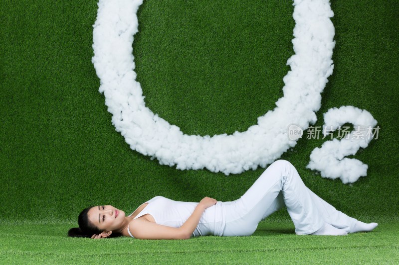 草地创意年轻女性躺在草地上