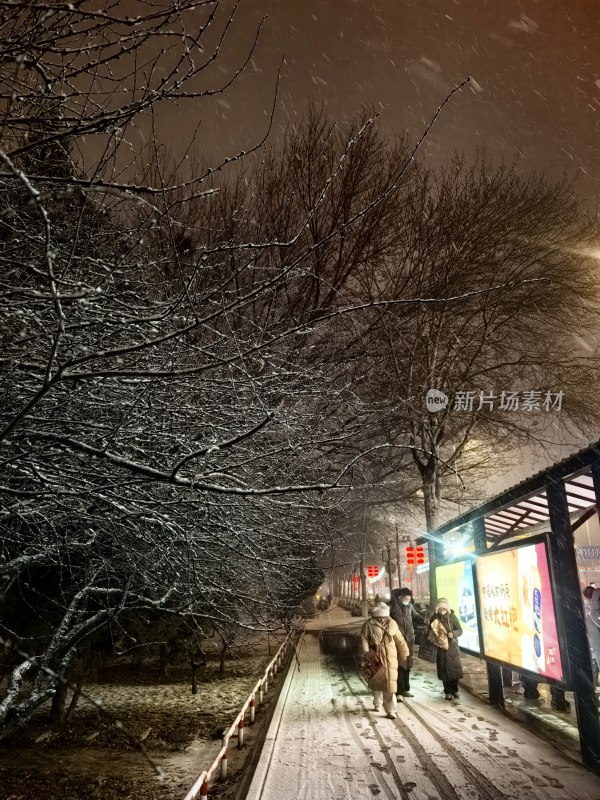 冬夜行人漫步飘雪街道