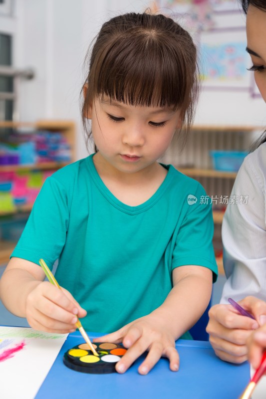 幼儿园女老师辅导儿童画画