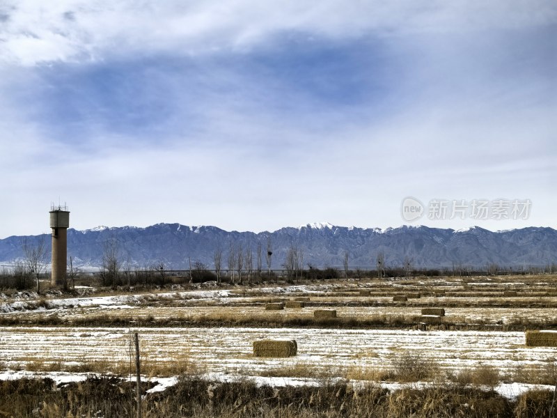 雪山下的田野与水塔景观