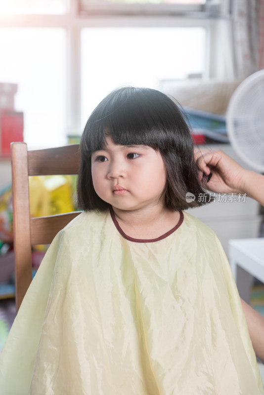 在家剪头发的中国女童