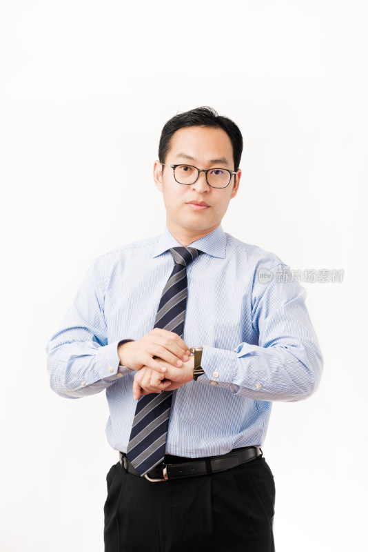 站在白色背景前穿正装看手表的亚洲男士