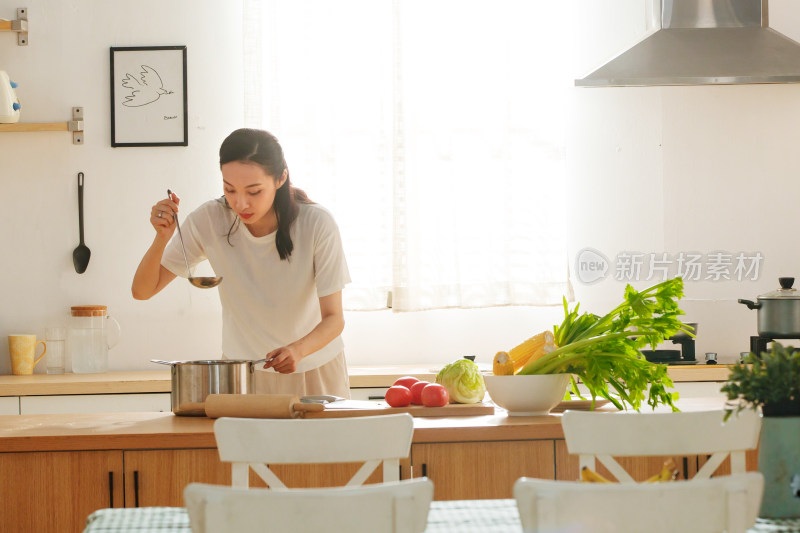 青年女人在厨房里做饭