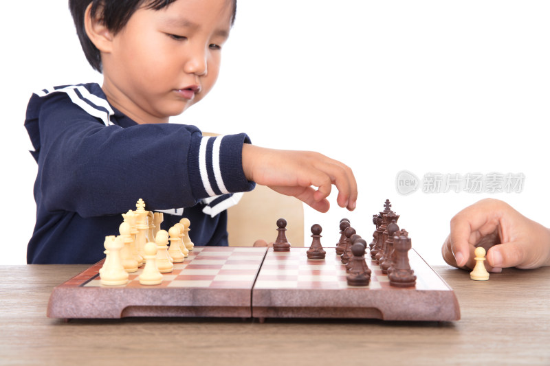 白背景前小孩子在学习下国际象棋