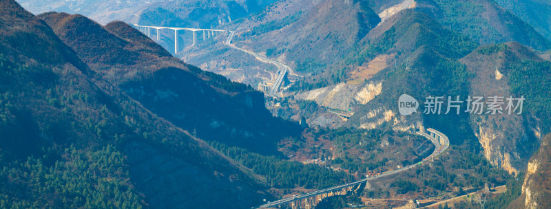 山间城镇全景，高架公路贯穿其中