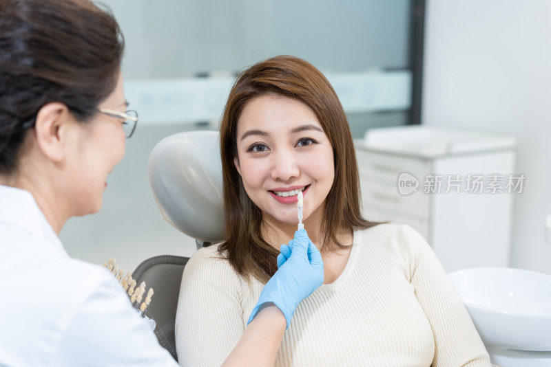 医生给患者在牙科诊所匹配牙齿