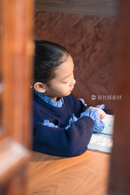 坐在房间内认真看书的中国女孩