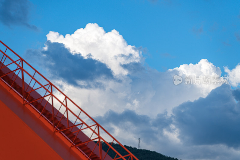 蓝天白云下的红色斜拉索桥
