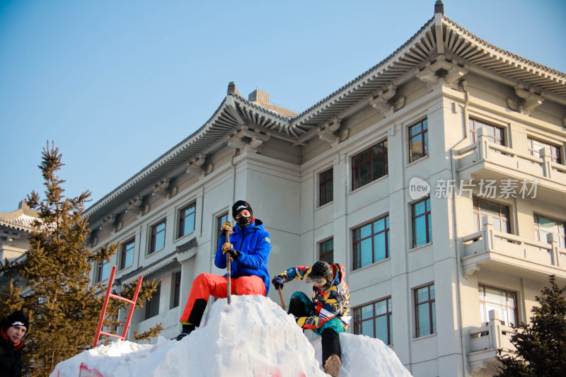 在哈尔滨人们户外合作制作大型雪雕