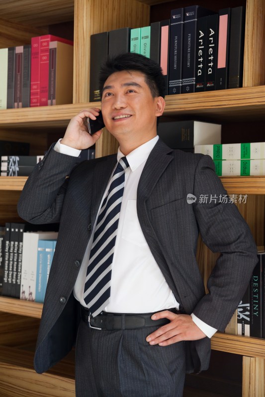 中年商务男士在书柜前打手机