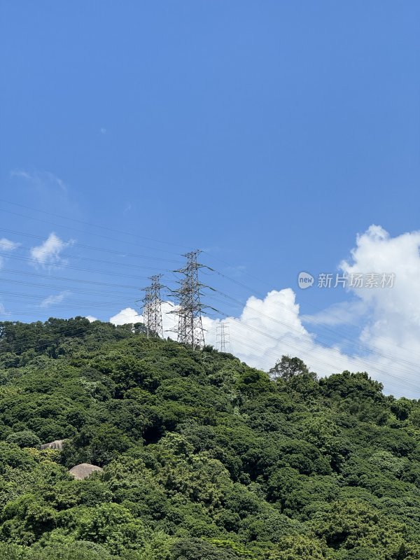 山上面的输电塔与云朵