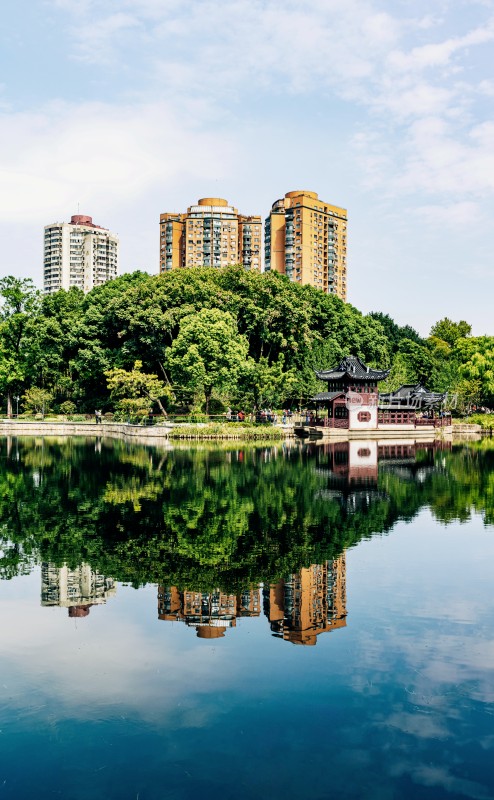 上海和平公园湖边中式建筑与城市高楼倒影