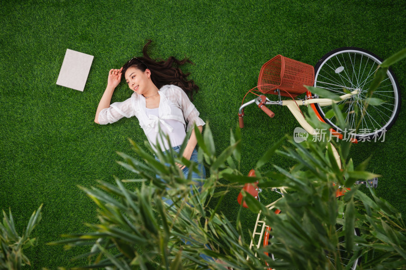 躺在草地上享受生活的青年女人