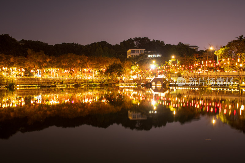 夜晚城市公园湖面倒映的璀璨灯光